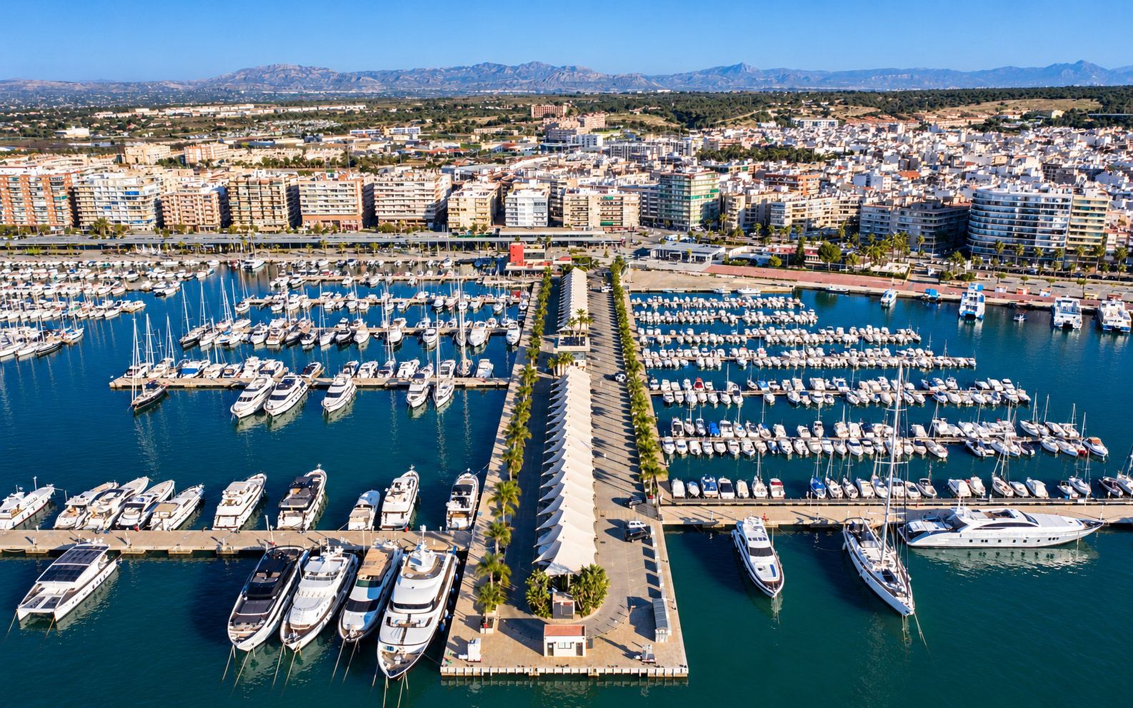 Vista aérea de un puerto deportivo con pantalanes, barcos amarrados y travel lift